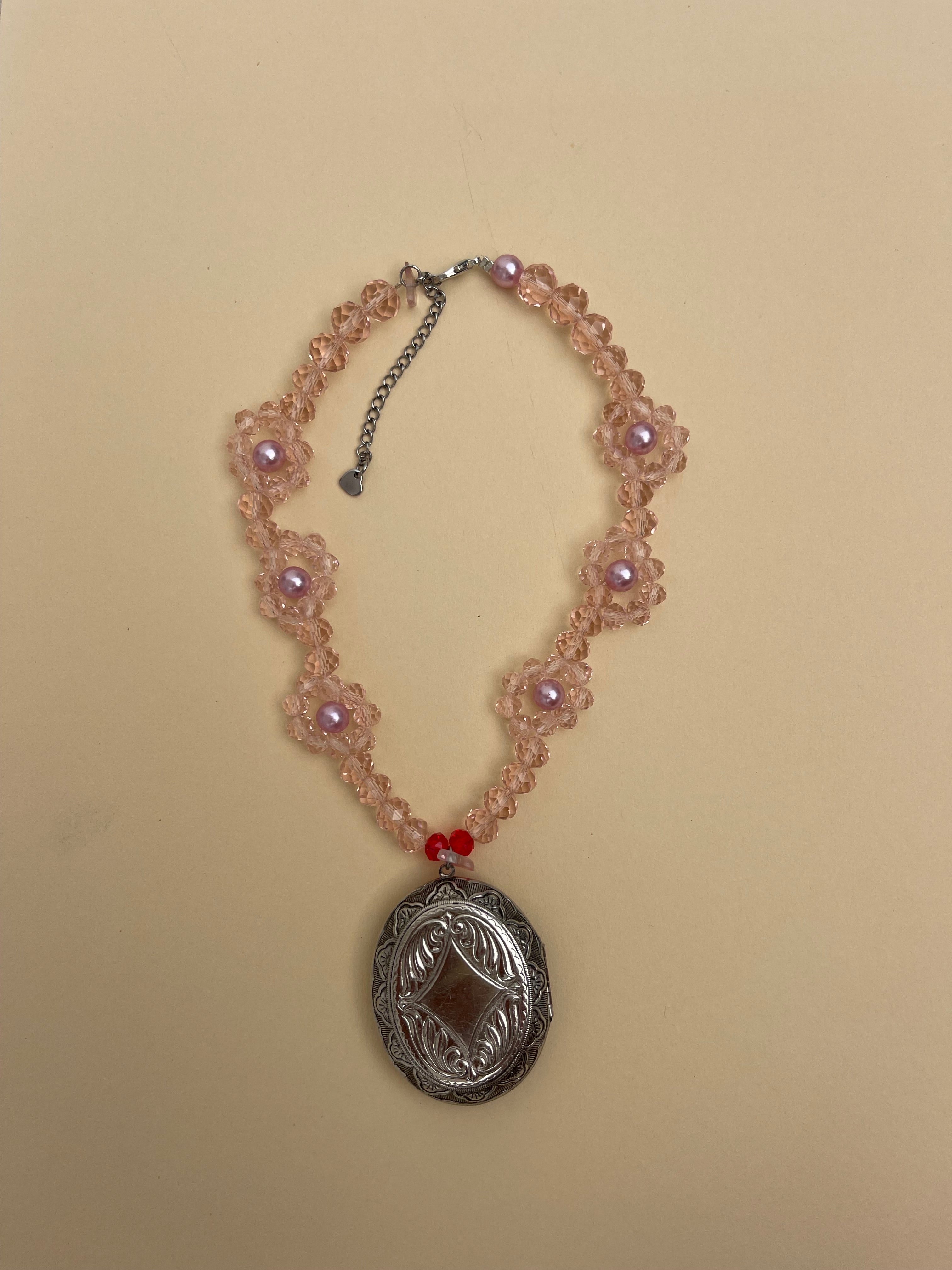 Locket on pink daisy chain